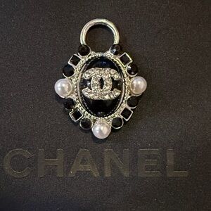 Oval Shaped Chanel 19 cc A Pendant set in black and pearl with its logo.